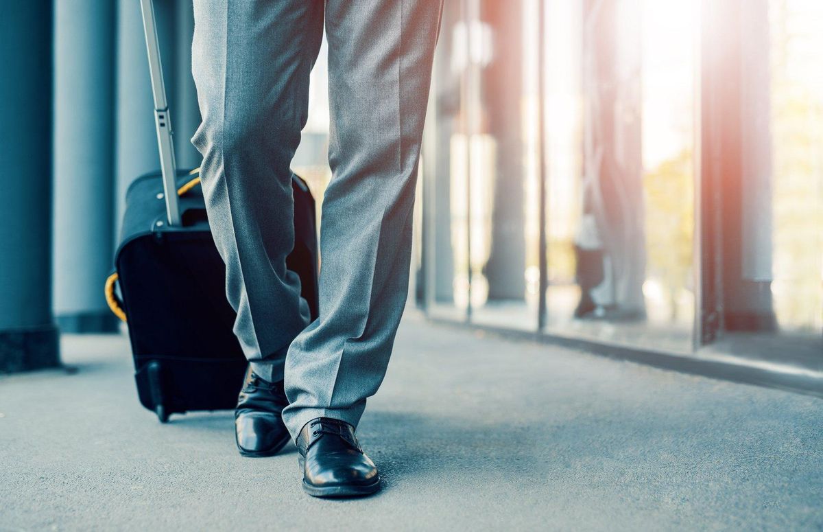 Business traveler pulling suitcase