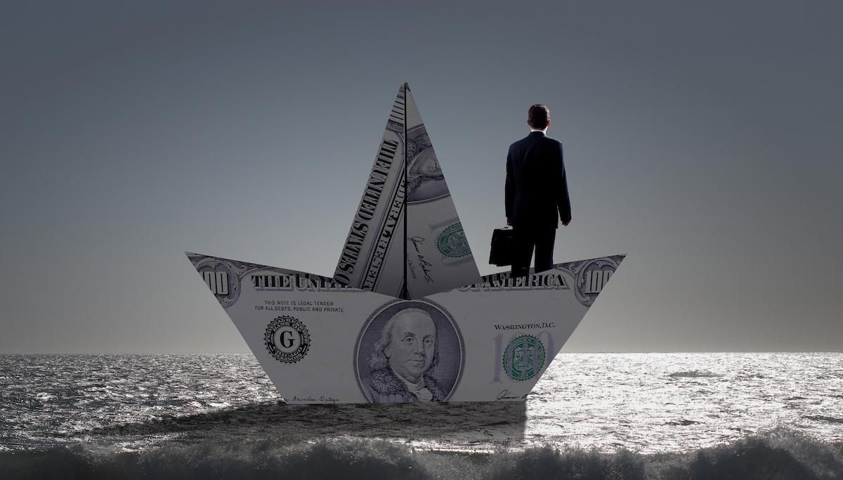 businessman on boat made from money