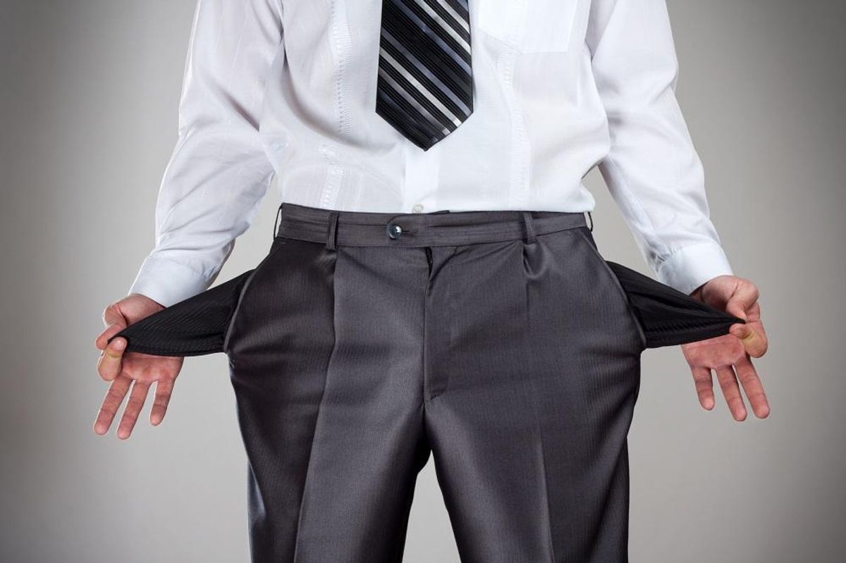 Businessman pulling empty pockets out of pants