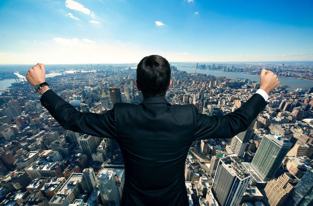 Businessman raising his arms in front of a big city
