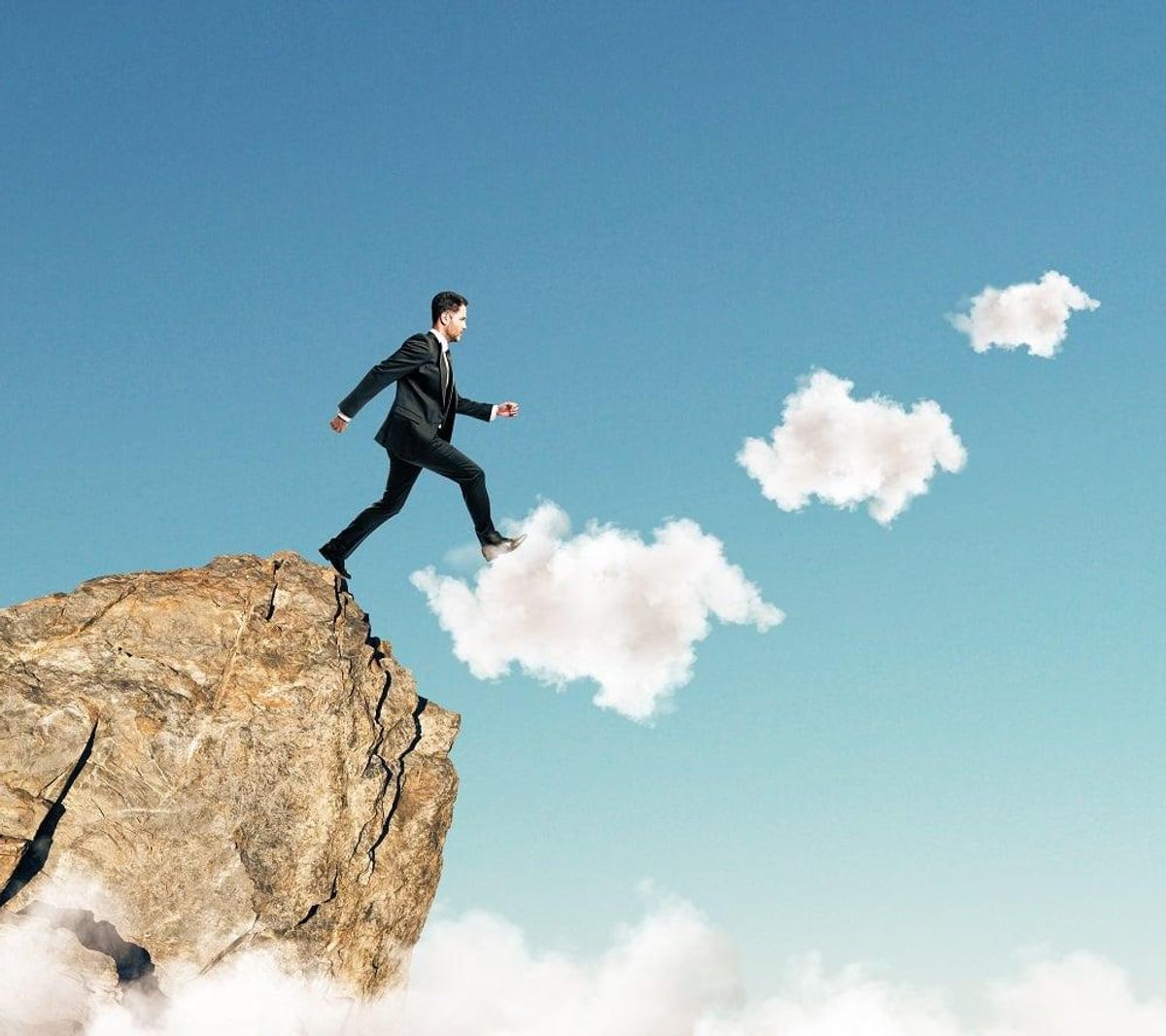 Businessman stepping on clouds to achieve success in his career