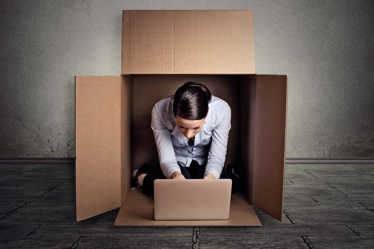 Businesswoman sitting in a box representing an introvert