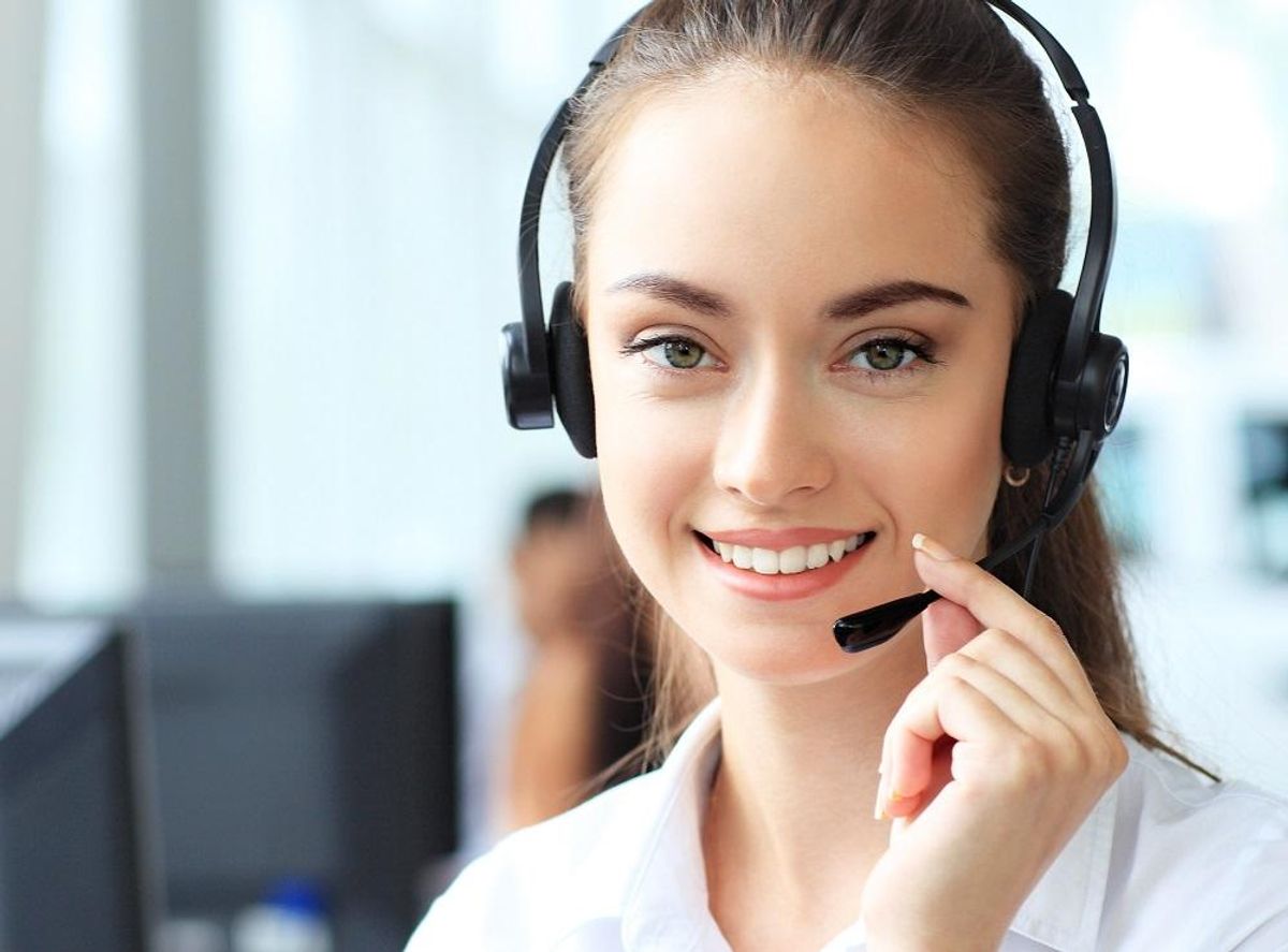 Female customer support operator with headset and smiling
