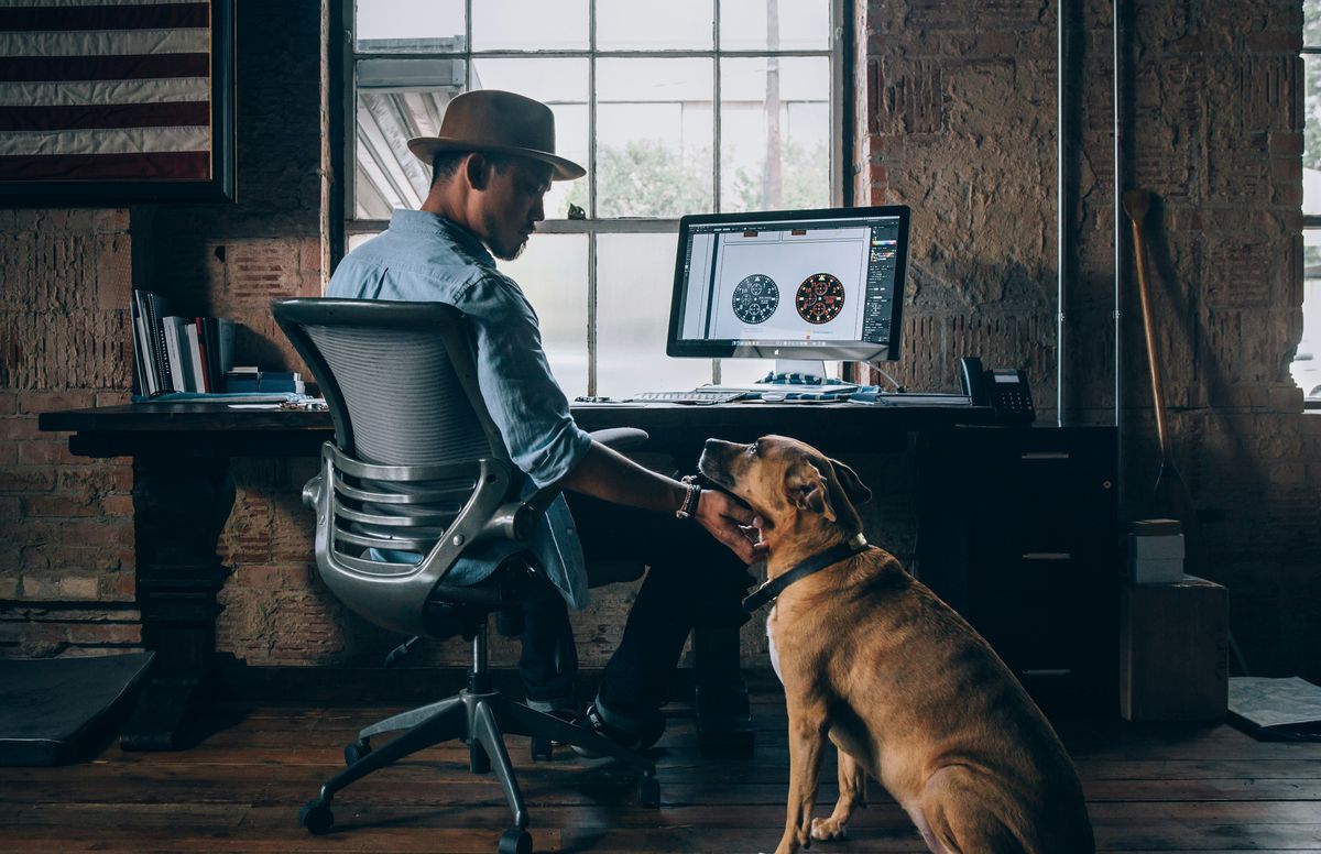 Man enjoying the benefit of having his dog at work