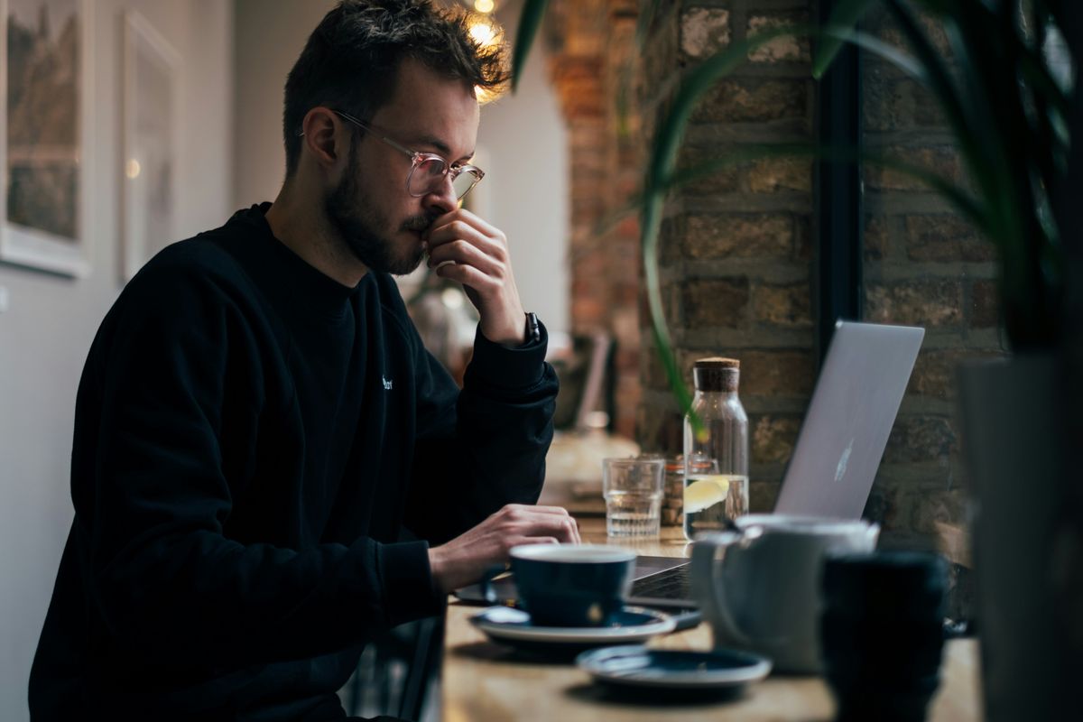 Man working at a coffee shop over the weekend to start his small business