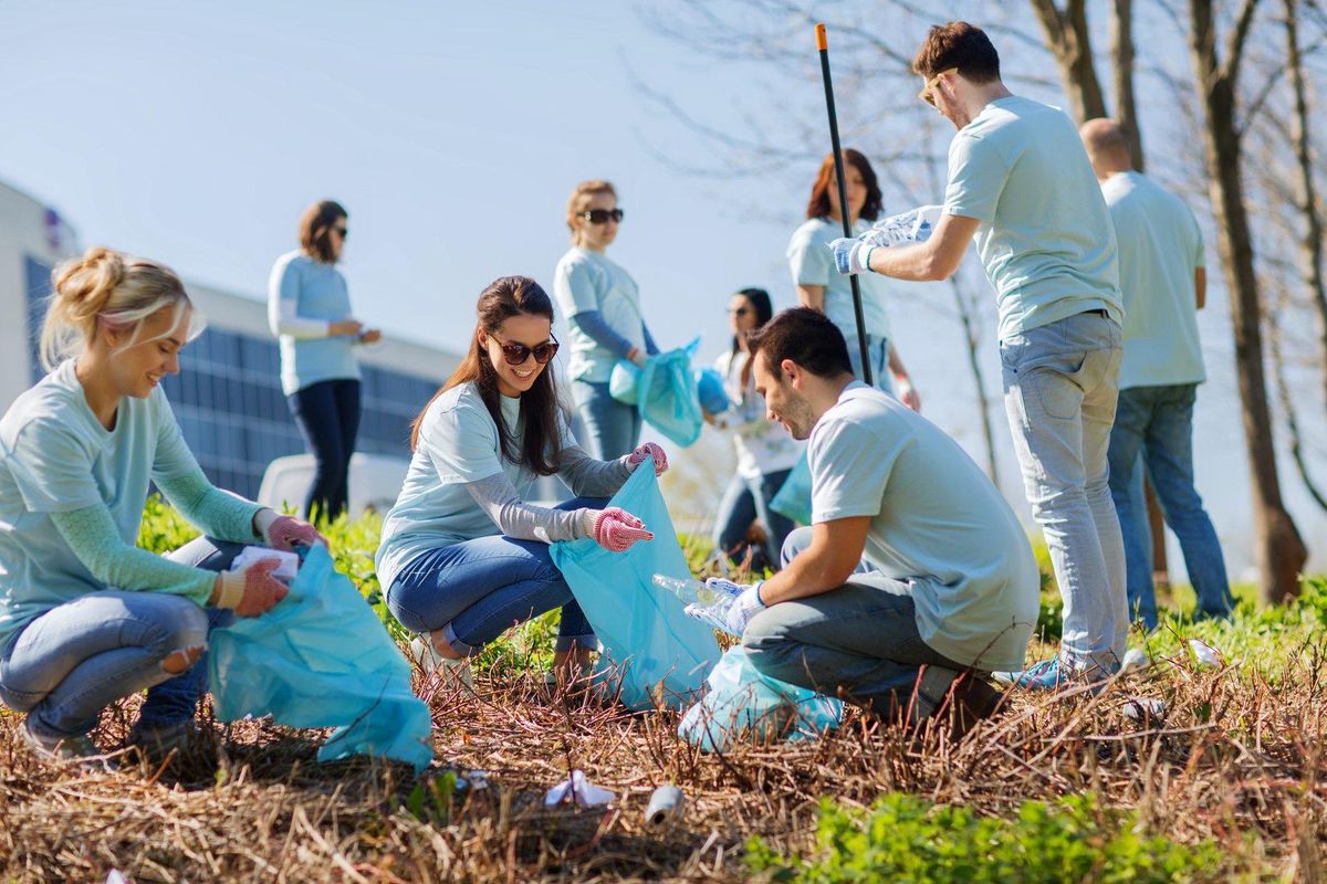volunteer with a volunteer time off program with garbage bags cleaning park area