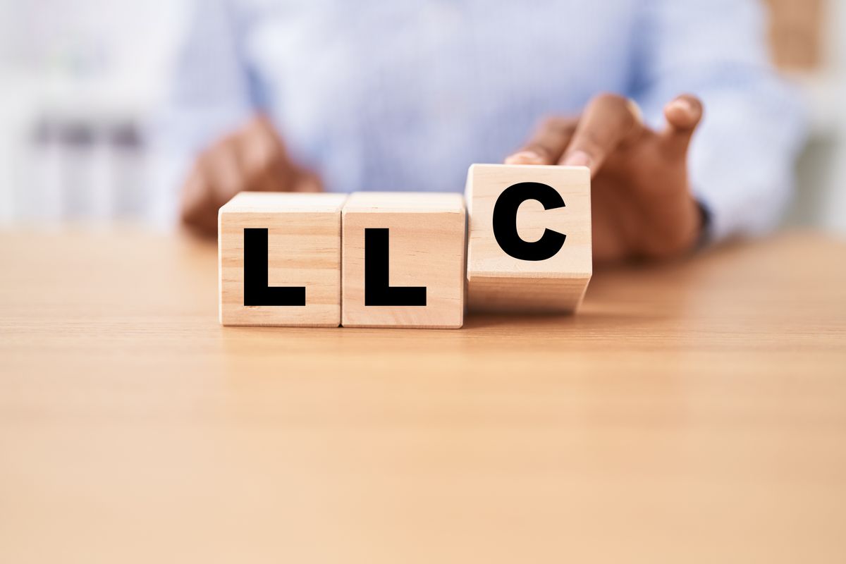 Woman holding cubes with llc word on the table