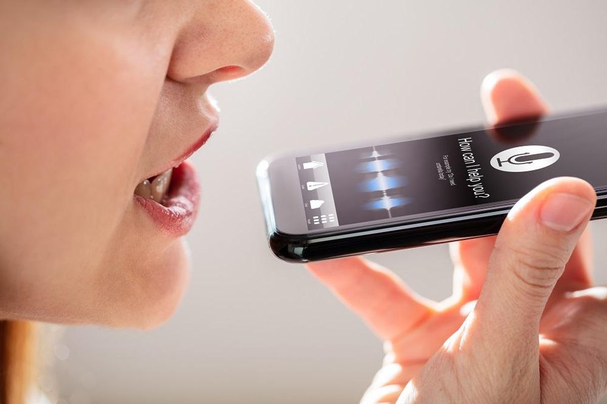 Woman Using Voice Recognition Function On Mobile Phone